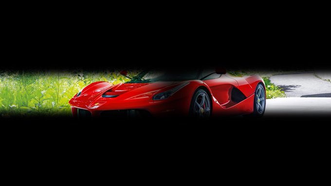 Red Ferrari visible through an extremely narrow horizontal opening in black